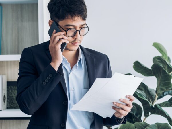 Asian businessman standing and talking on smart phone contact